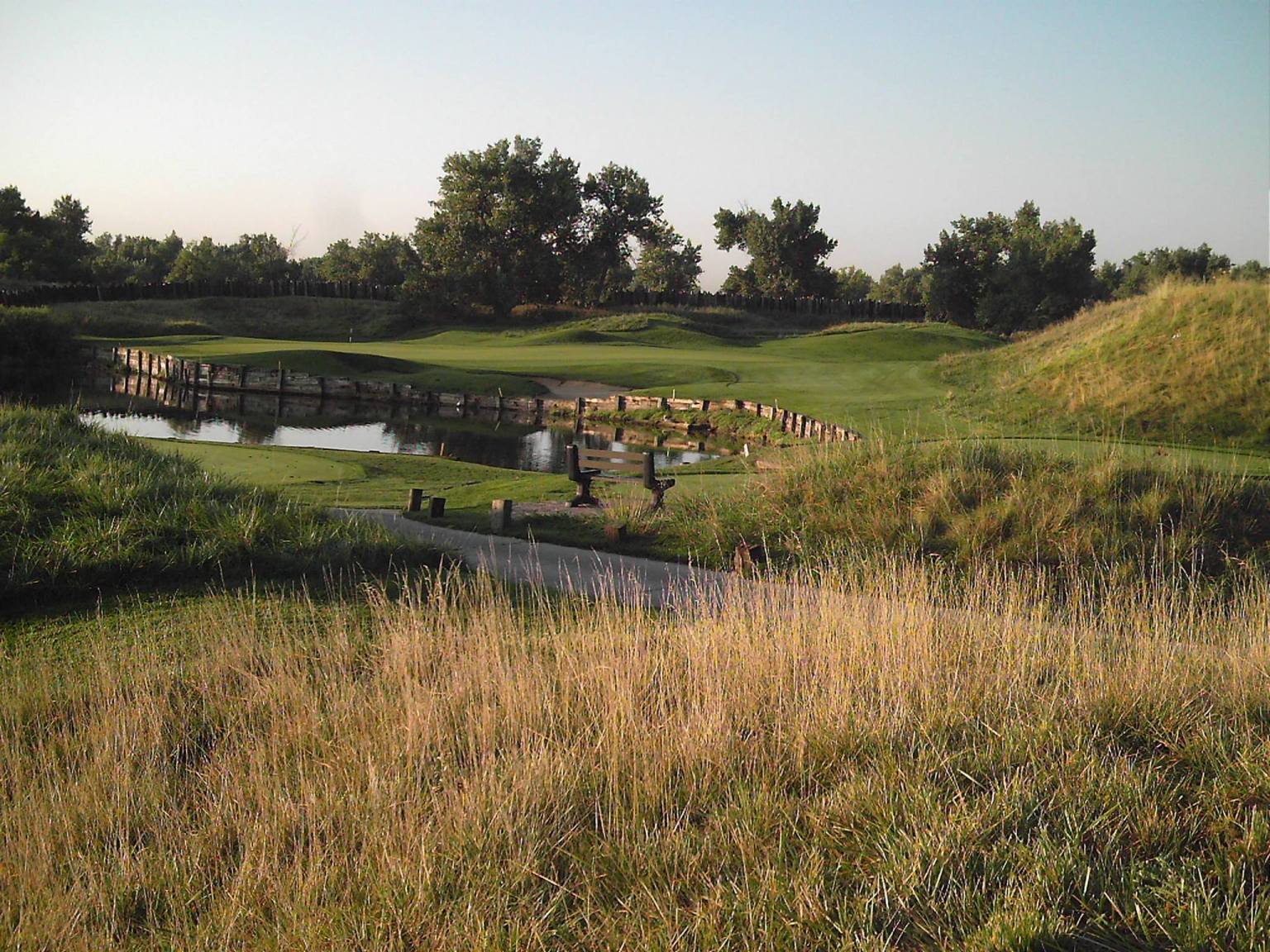 View of pond and bridge on golf course
